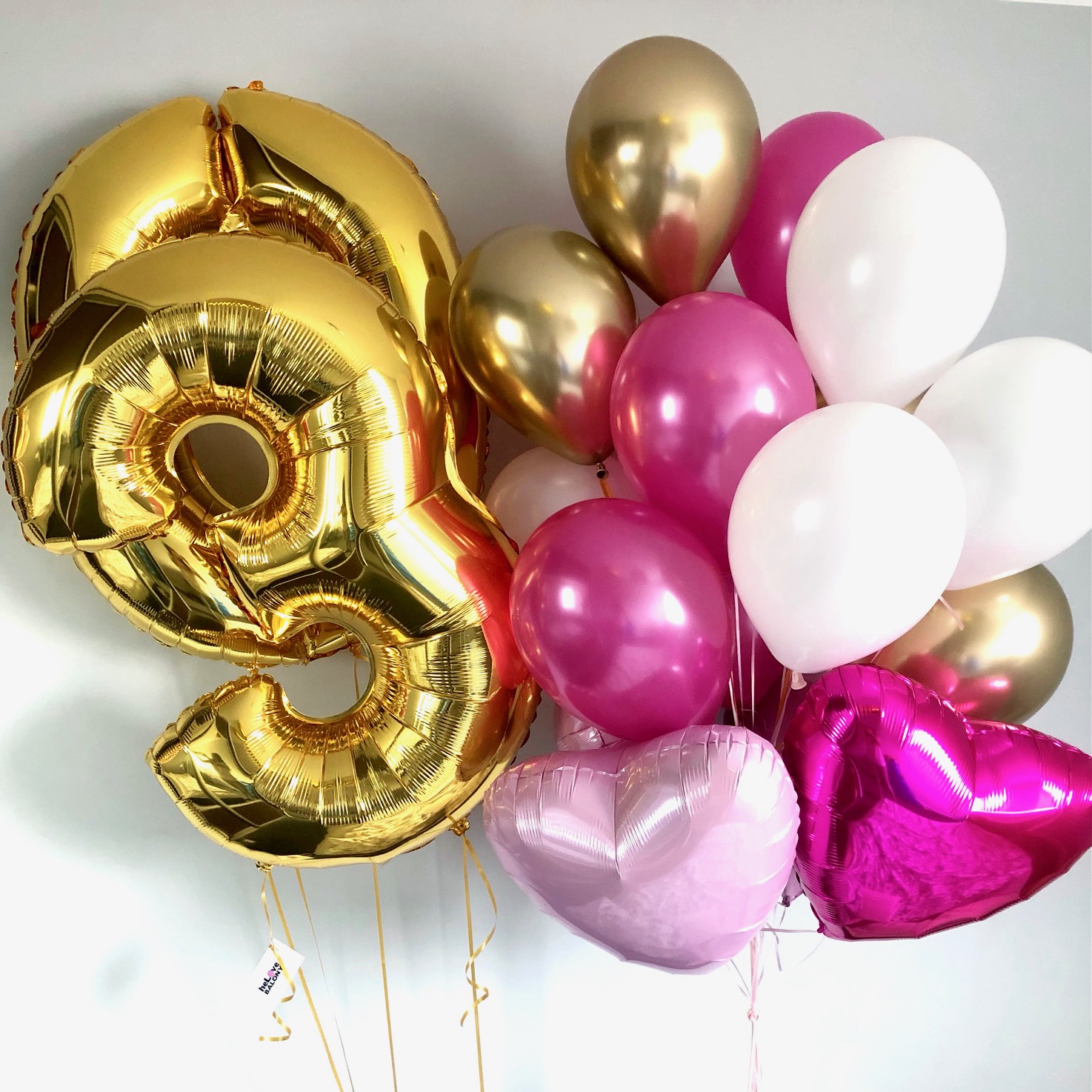 Złote cyfry z helem i balony różowo złote na urodziny
